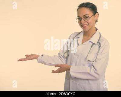 Studioaufnahme von glücklichen schönen Frau Arzt lächelnd während der Vorführung Etwas und Brillen tragen Stockfoto