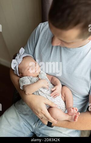 Junge kaukasische Vater hält neugeborenes Mädchen. Männlicher Mann Eltern und Kind Tochter. Authentischer Lifestyle dokumentarischer Moment. Alleinstehend Vater Familienleben Stockfoto