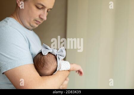 Junge kaukasische Vater hält neugeborenes Mädchen. Männlicher Mann Eltern und Kind Tochter. Authentischer Lifestyle dokumentarischer Moment. Alleinstehend Vater Familienleben Stockfoto