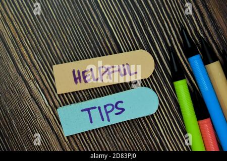 Hilfreiche Tipps Schreiben Sie auf Haftnotiz und isoliert auf Holztisch. Geschäftskonzept. Selektiver Text „auf hilfreiche Tipps konzentrieren“ Stockfoto