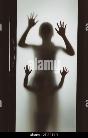 Konzept Schatten von Mutter und Kind hinter dem matten Glas Verschwommener Hand- und Körperfokus Stockfoto