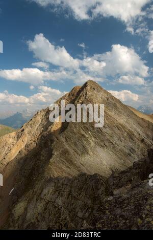 Die Spitze der Bergkette gegen einen blauen Himmel Mit Wolken Stockfoto