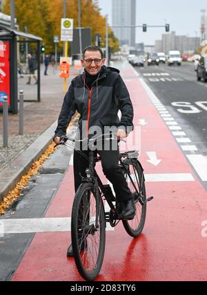 26. Oktober 2020, Berlin: Stephan von Dassel (Bündnis 90/die Grüne), Bezirksbürgermeister von Berlin Mitte, fährt mit dem Fahrrad auf der neu gestalteten Karl-Marx-Allee mit breiten Fahrradwegen, besseren Kreuzungsmöglichkeiten für Fußgänger und einem bald grünen Zentralreservat. Die Sektion wurde heute nach 28 Monaten Bauzeit übergeben. Der Umbau der Hauptstraße zwischen Strausberger Platz und Otto-Braun-Straße wurde zugunsten des Fußgänger- und Fahrradverkehrs durchgeführt. Statt Parkplätze gibt es beispielsweise eine Grünfläche in der Mitte der Karl-Marx-Allee. Foto: Jens K Stockfoto