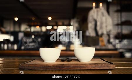 Porträt von zwei Kaffeetassen frisch zubereitet und dampfend auf Tafeln im trendigen Café Stockfoto