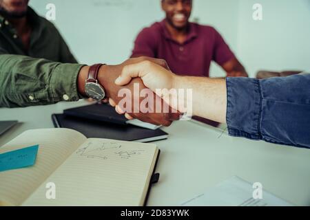 Nahaufnahme des Partners und des Chefs, der die Hände schüttelt und erfolgreich schließt Business Deal Bonus im Sitzungs-Raum während des Teams Besprechung Stockfoto
