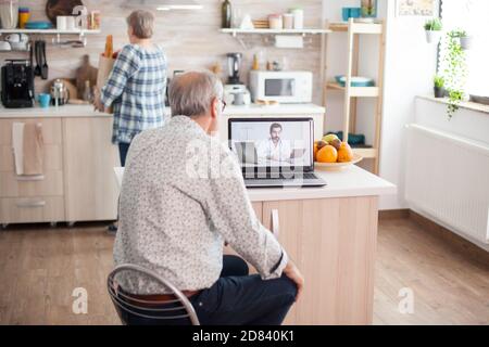 Seniorenpaar mit einer Videokonferenz mit Arzt reden schlechte Behandlung. Online-Gesundheitsberatung für ältere Menschen Drogen Unsinn Beratung über Symptome, Arzt Telemedizin Webcam. Medizinische Versorgung Internet-Chat Stockfoto