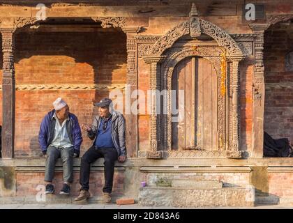 Ältere Männer sprechen auf den Stufen eines Tempels auf dem Durbar-Platz in Kathmandu, Nepal Stockfoto