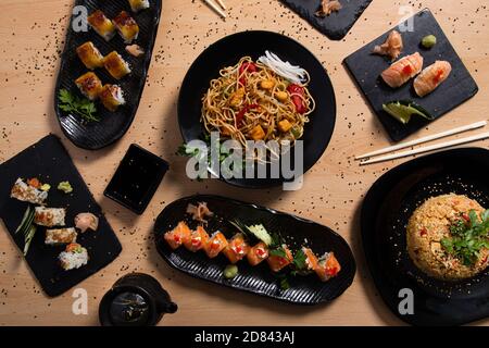 Gemischte Auswahl an verschiedenen japanischen Gerichten auf Holzhintergrund. Speisekarte im Restaurant. Stockfoto