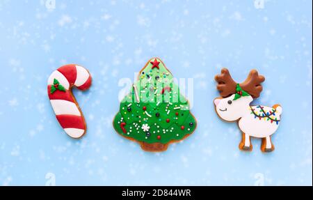 Hausgemachte Lebkuchenkekse in Form von Neujahrsdekorationen auf blauem Hintergrund. Weihnachtskonzept. Flach liegend. Cspace kopieren. Draufsicht. Stockfoto