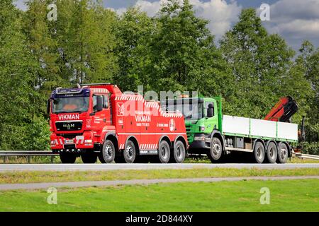 Kranwagen wird von MAN TGS 41.440 Schwerlast-Schlepper von Hinauspalvelu J Vikman Ky entlang der Autobahn 2 geschleppt. Forssa, Finnland. August 2020. Stockfoto