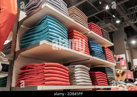 Gestapelte farbige Stapel von Kleidung in einem Boutique-Shop auf der Theke. Einkaufen vor Ort Stockfoto