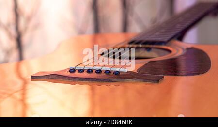 Akustische Gitarre auf einem schönen farbigen Hintergrund. Das Konzept der Saiteninstrumente. Nahaufnahme. Stockfoto