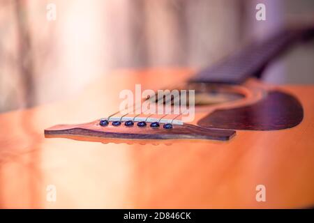 Akustische Gitarre auf einem schönen farbigen Hintergrund. Das Konzept der Saiteninstrumente. Nahaufnahme. Stockfoto