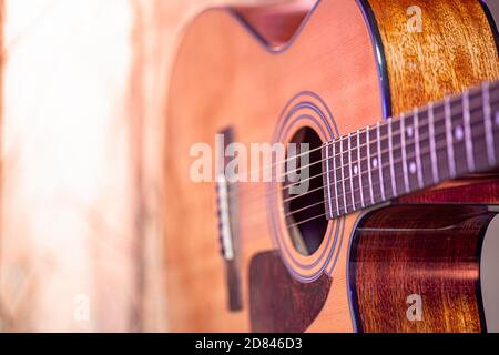 Akustische Gitarre auf einem schönen farbigen Hintergrund. Das Konzept der Saiteninstrumente. Nahaufnahme. Stockfoto