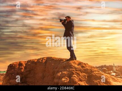 Ein männlicher Fotograf auf einem Felsen Stockfoto