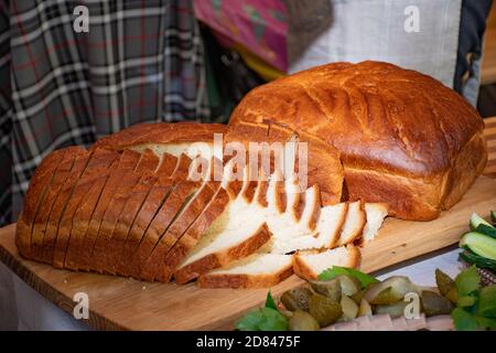 Weißbrot oder Brotscheiben auf einem Holzbrett Stockfoto