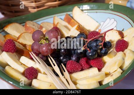 Teller gefüllt mit Vorspeisen, Vorspeisen und Snacks, Speisen für ein Festmahl, litauische oder nordeuropäische oder baltische Speisen, Käse und Obst, Trauben Stockfoto