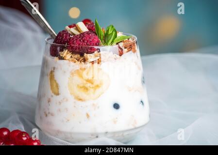 Beerenobst-Parfait mit Pudding und Sahne mit Früchten gekrönt In einer Glasschale Nahaufnahme Stockfoto
