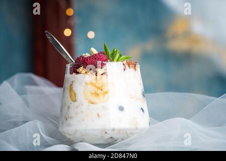 Beerenobst-Parfait mit Pudding und Sahne mit Früchten gekrönt In einer Glasschale Nahaufnahme Stockfoto