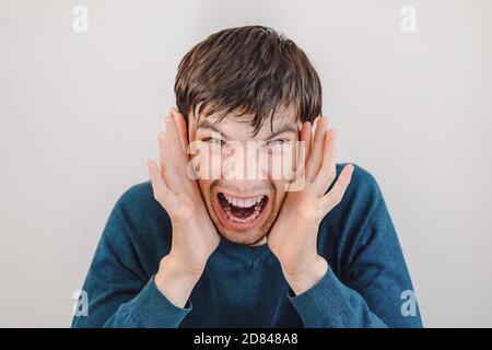 Nahaufnahme. Lässiger emotionaler junger Mann schreit. Stockfoto