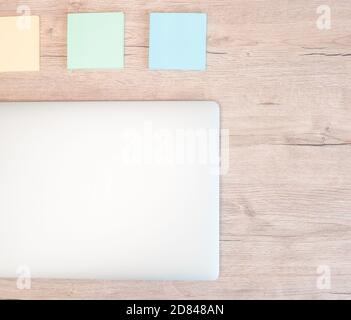 Nahaufnahme. Haftnotizen und ein weißer Laptop auf dem Tisch. Stockfoto