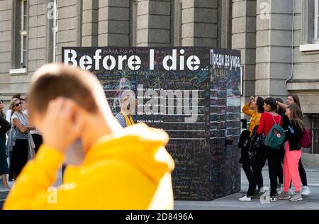 Passanten schreiben und lesen Nachrichten auf einer Tafel oder Tafel Wand für das öffentliche interaktive Kunstprojekt Before I die In Sofia Bulgarien Stockfoto