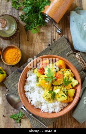 Indische Küche Gericht Sabji. Traditioneller indischer Gemüseeintopf mit Weichkäse, Kurkuma und Reis auf einem Holztisch.Draufsicht flacher Hintergrund. Stockfoto