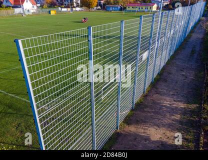 Schwerin, Deutschland. Oktober 2020. Auf einer Seite des Sportfeldes des Sportvereins Neumühler steht ein Lärmschutzzaun, während im Hintergrund die Wiese gemäht wird (Luftaufnahme mit Drohne). Die Vereinigung der Steuerzahler hat den Zaun als Beispiel für die Verschwendung von Steuergeldern in ihrem Black Book 2020/21 veröffentlicht. Quelle: Jens Büttner/dpa-Zentralbild/dpa/Alamy Live News Stockfoto