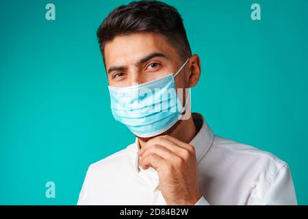 Schöner Mann mit gemischter Rasse, der eine medizinische Gesichtsmaske trägt Stockfoto