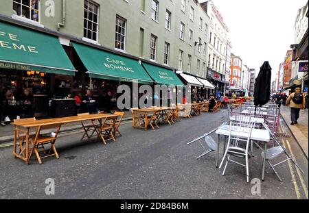 Die abgesperrte Straße von Soho mit Tischen und Stühlen ist praktisch leer von Essern.kämpfende Bars und Restaurants in London werden am Ende dieser Woche an der Kreuzung sein. Es ist ein paar Tage vor dem Ende des Programms der Straßensperrungen in Soho und Covent Garden, die Restaurants und Bars erlaubt hat, Tische in den Straßen zum ersten Mal setzen. Soho wurde in ein Restaurantviertel unter freiem Himmel verwandelt, aber wenn der Winter naht, sind Straßen in der Kälte und im Regen praktisch leer und mit der Aussicht auf eine weitere Sperre sehen viele Unternehmen, die sich so sehr bemüht haben, es zu schaffen, so aus, als wären sie es Stockfoto