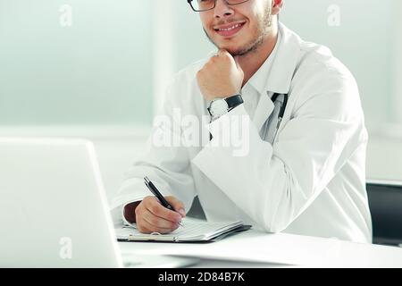 Arzt, Therapeuten, die an einem Tisch sitzt in seinem Büro Stockfoto
