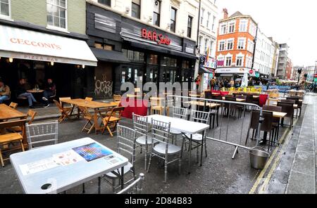 Tische und Stühle sind in dieser Straße in Soho leer.am Ende dieser Woche stehen die kämpfenden Bars und Restaurants in London an der Kreuzung. Es ist ein paar Tage vor dem Ende des Programms der Straßensperrungen in Soho und Covent Garden, die Restaurants und Bars erlaubt hat, Tische in den Straßen zum ersten Mal setzen. Soho wurde in ein Restaurantviertel unter freiem Himmel verwandelt, aber wenn sich der Winter nähert, sind die Straßen in der Kälte und im Regen praktisch leer und mit der Aussicht auf eine weitere Sperre sehen viele Unternehmen, die sich so sehr bemüht haben, es zu schaffen, aus, als würden sie gezwungen, ihre Geschäfte zu schließen - Stockfoto