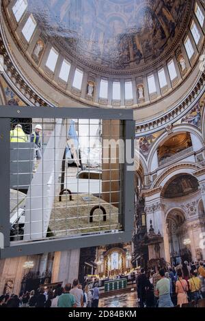 Durch eine Öffnung eines Bauhorts gesehen, arbeiten Arbeiter auf dem Gelände der St. Paul's Cathedral weiter, wo der neue Nordeingang bald, am 26. Oktober 2020, in London, England, fertiggestellt wird. Stockfoto