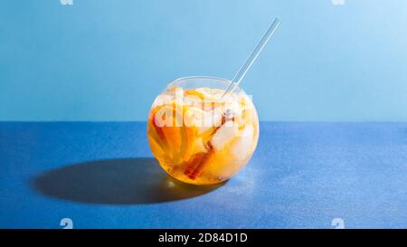 Sangria Punch Cocktail mit Orange, Apfel und Zimt auf blauem Hintergrund. Fruchtgetränk für Party Stockfoto