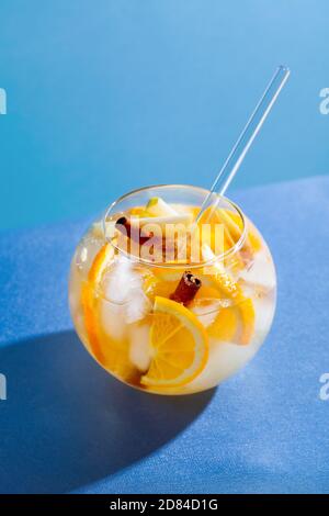 Sangria Punch Cocktail mit Orange, Apfel und Zimt auf blauem Hintergrund. Fruchtgetränk für Party Stockfoto