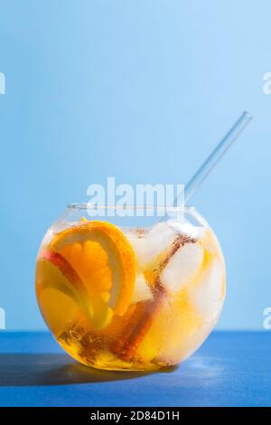Sangria Punch Cocktail mit Orange, Apfel und Zimt auf blauem Hintergrund. Fruchtgetränk für Party Stockfoto