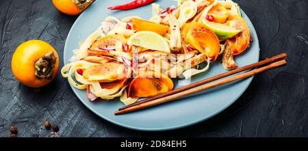 Orientalisches Essen, Salat mit Nudeln, Kaki und Auberginen. Gesunder asiatischer Salat Stockfoto