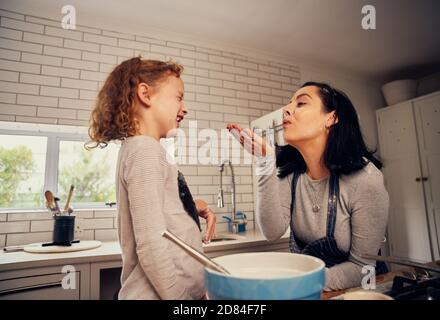 Verspielte Mutter und Tochter beim Kochen mit Mehl In moderner Küche zu Hause Stockfoto