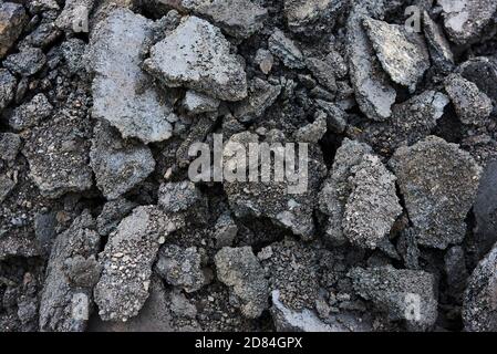 Zerbrochene Asphaltstücke auf einer Baustelle. Recycling und Wiederverwendung zerkleinerten Betonschutt, Asphalt, Baumaterial, Blöcke. Zerkleinert сoncrete Stockfoto