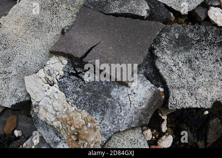 Zerbrochene Asphaltstücke auf einer Baustelle. Recycling und Wiederverwendung zerkleinerten Betonschutt, Asphalt, Baumaterial, Blöcke. Zerkleinert сoncrete Stockfoto