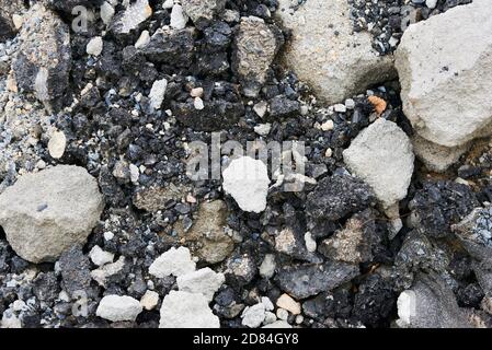 Zerbrochene Asphaltstücke auf einer Baustelle. Recycling und Wiederverwendung zerkleinerten Betonschutt, Asphalt, Baumaterial, Blöcke. Zerkleinert сoncrete Stockfoto