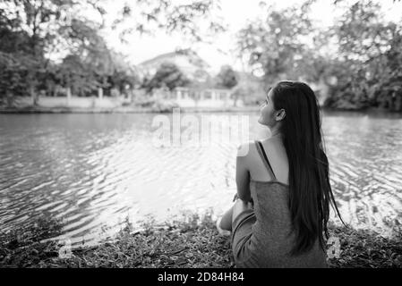 Junge schöne asiatische Frau Entspannen am See im Park Stockfoto