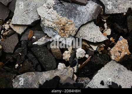 Zerbrochene Asphaltstücke auf einer Baustelle. Recycling und Wiederverwendung zerkleinerten Betonschutt, Asphalt, Baumaterial, Blöcke. Zerkleinert сoncrete Stockfoto
