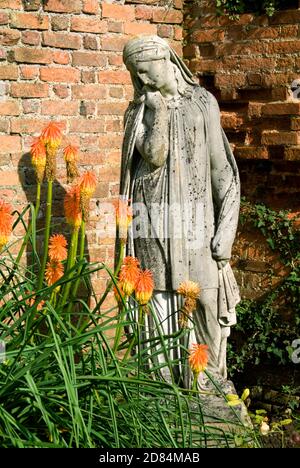 Skulptur und rote Hot Pokers, ummauerter formeller Garten, tredegar House, newport, gwent, südwales. Stockfoto