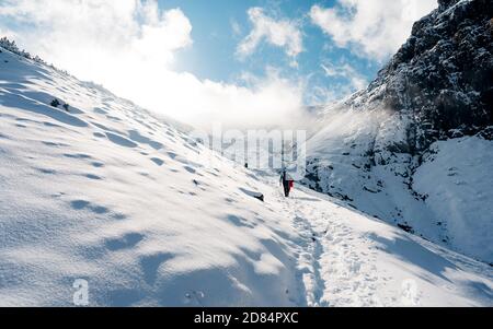 Aufstieg zum Gipfel. Winter Eis und Schnee Klettern in den Bergen. Ein Erfolg des Bergsteigers, der den Gipfel erreicht. Outdoor-Abenteuersport Stockfoto