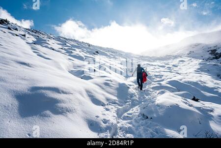 Aufstieg zum Gipfel. Winter Eis und Schnee Klettern in den Bergen. Ein Erfolg des Bergsteigers, der den Gipfel erreicht. Outdoor-Abenteuersport Stockfoto