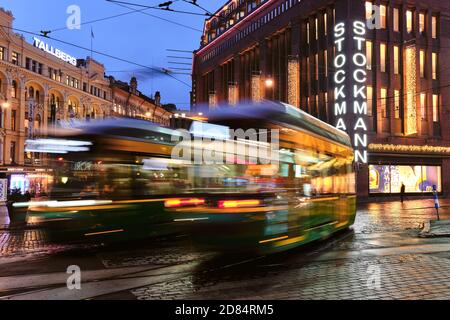 Helsinki, Finnland - 26. Oktober 2020: Die Straßenbahnen fahren auf der Aleksanterinkatu Straße. Der regnerische Herbstabend. Stockfoto