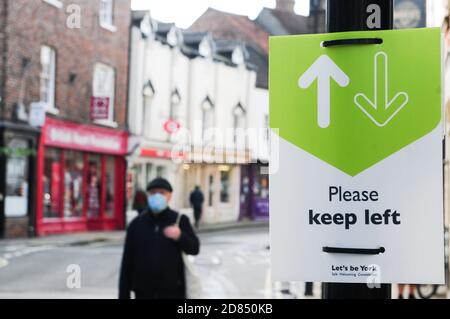 york, UK, england, 25-10-2020, Sign on lamp post in der Stadt York, um Menschen nach links zu halten, um der sozialen Distanzierung während der Strömung zu helfen Stockfoto