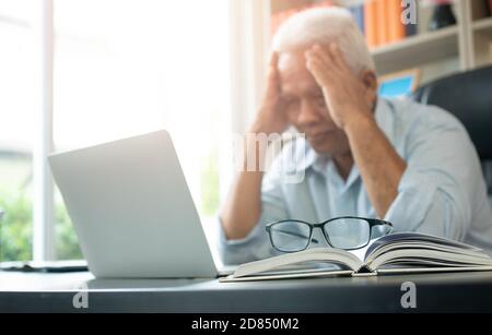 Happy Senior Asian mit dem Laptop für die Berechnung und notieren Sie sich die täglichen Ausgaben. Konzept von Lifestyle, Lernen und Finanzgeschäft Stockfoto