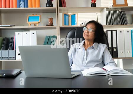 Happy Senior Asian mit dem Laptop für die Berechnung und notieren Sie sich die täglichen Ausgaben. Konzept von Lifestyle, Lernen und Finanzgeschäft Stockfoto